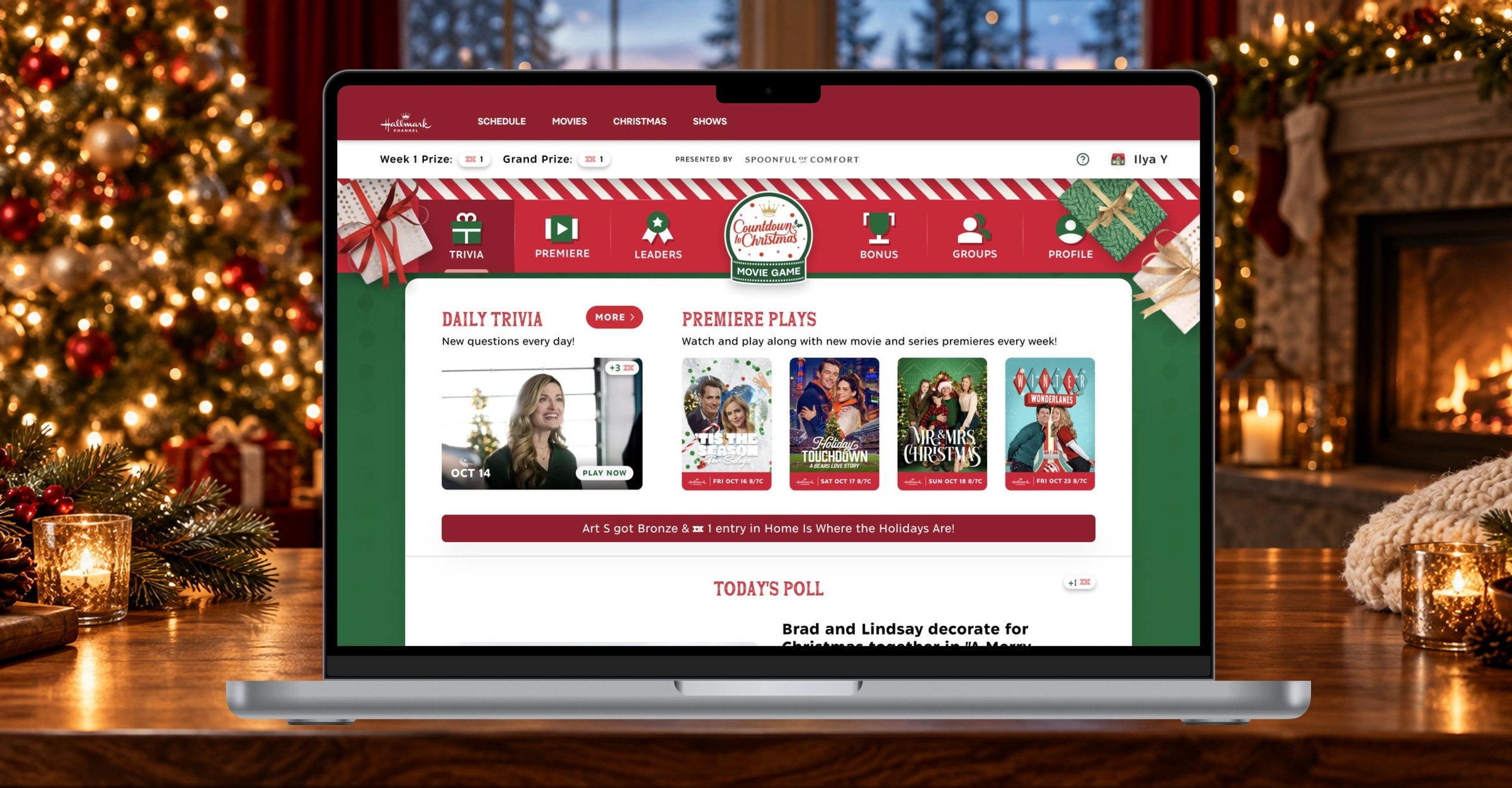 Hallmark’s Christmas Movie Game on a MacBook beside a glowing tree and fireplace